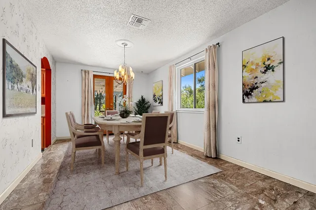 a view of an empty room with a window and a kitchen
