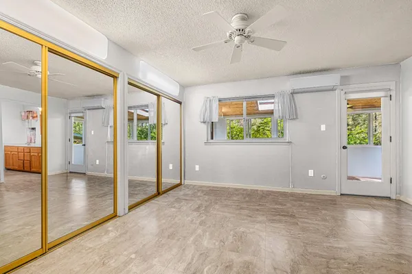 a large white bed sitting in a bedroom and living room