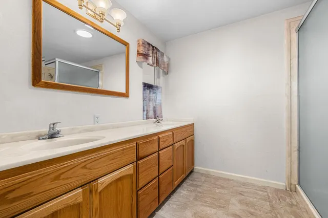 a spacious bathroom with a granite countertop sink and a large mirror