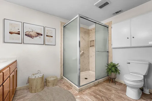 a view of a refrigerator in kitchen and an empty room