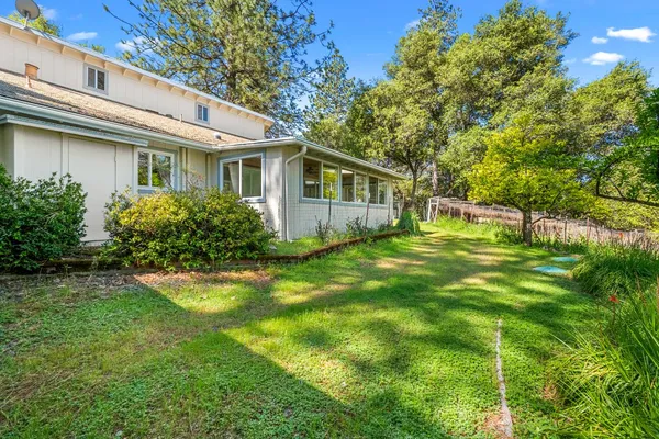 a view of a house with a yard and large tree