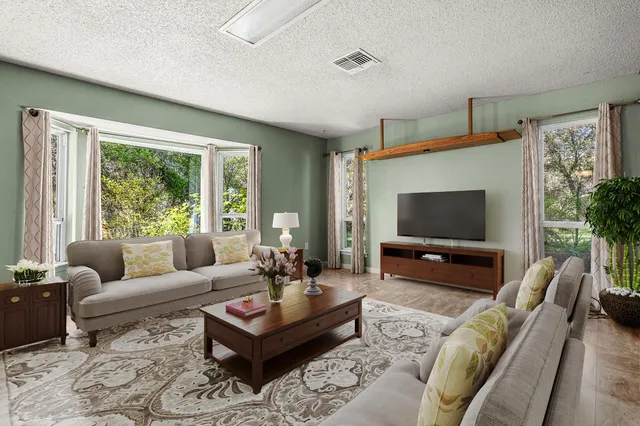 a living room with furniture fireplace and a window