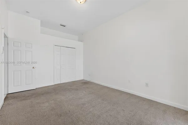 a view of an empty room with a chandelier fan