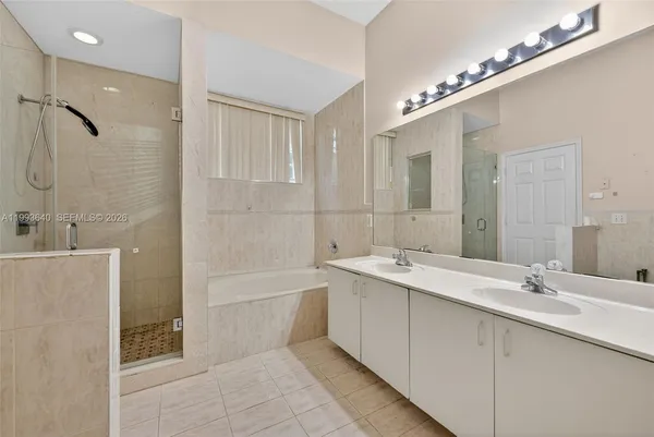 a bathroom with a tub sink shower and mirror