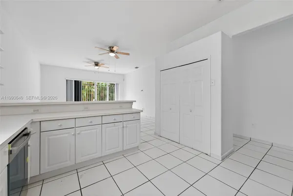 a kitchen with white cabinets a sink stove and refrigerator