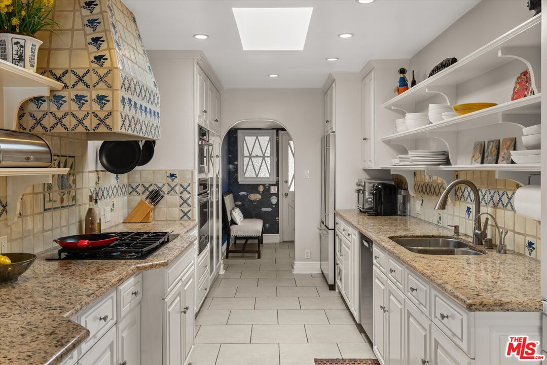 16355 Mandalay Drive Encino, CA 91436 - Photo 13 of 45 a kitchen with stainless steel appliances granite countertop a sink stove and refrigerator
