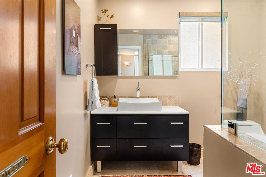 16355 Mandalay Drive Encino, CA 91436 - Photo 16 of 45 a bathroom with a double vanity sink and mirror