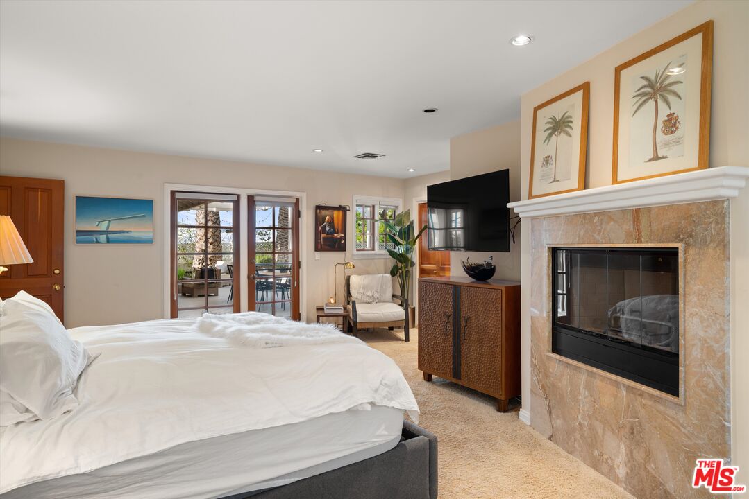 16355 Mandalay Drive Encino, CA 91436 - Photo 20 of 45 a bedroom with a large bed and a fireplace