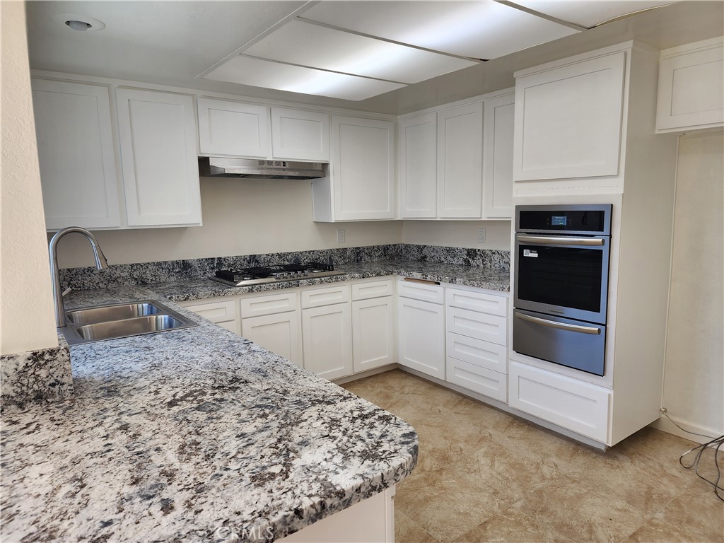 402 West Kelly Avenue, Unit A Orange, CA 92866 - Photo 1 of 13 a kitchen with granite countertop a stove sink and cabinets
