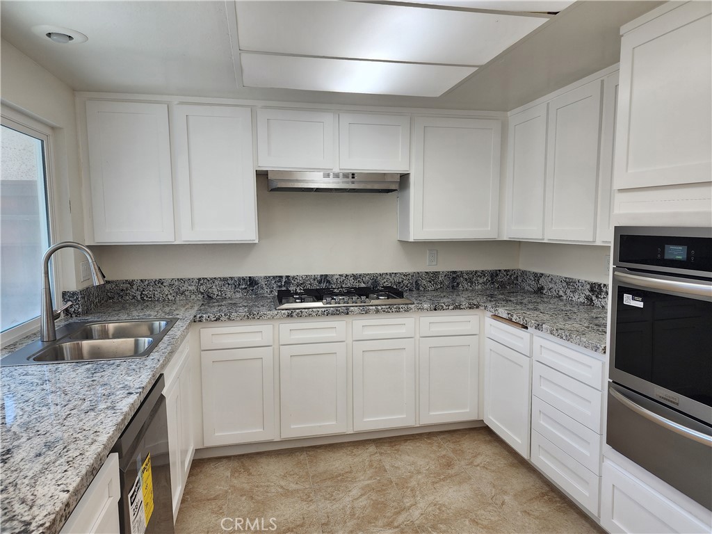 402 West Kelly Avenue, Unit A Orange, CA 92866 - Photo 4 of 13 a kitchen with stainless steel appliances granite countertop a sink stove and cabinets