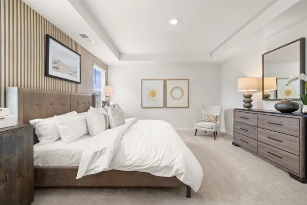 a spacious bedroom with a bed a lamp and a large window