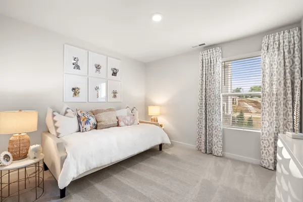 a large bed sitting in a bedroom next to a window