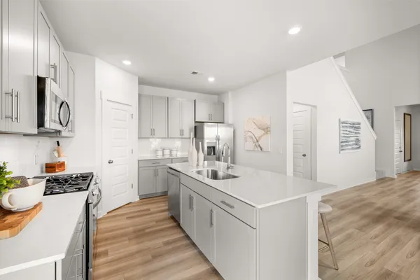 a kitchen with a sink stove and refrigerator