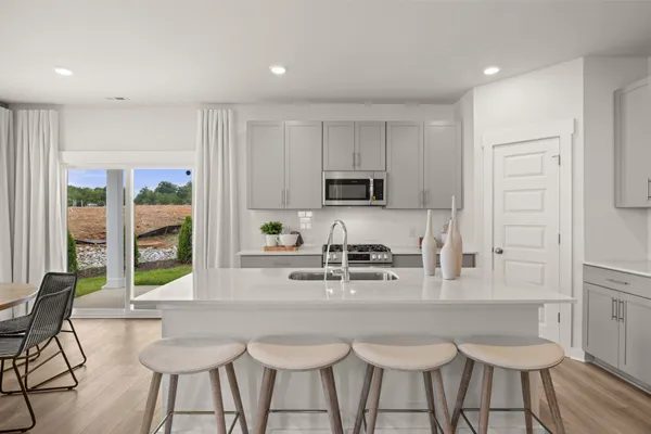 a kitchen with stainless steel appliances kitchen island granite countertop a stove a sink and a white cabinets
