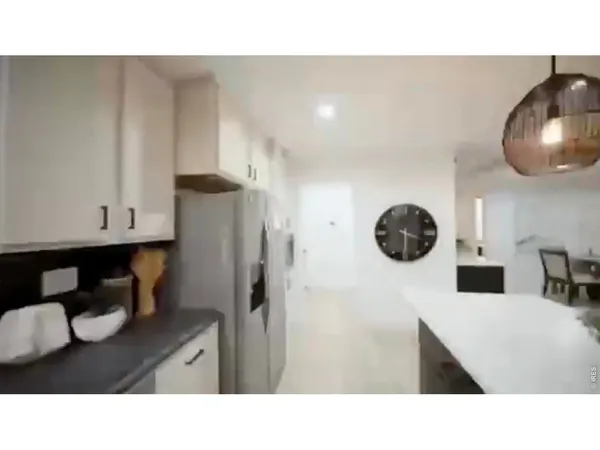 a kitchen view of a refrigerator and a sink
