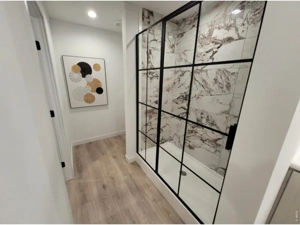 a large white kitchen with kitchen island a large counter space and stainless steel appliances