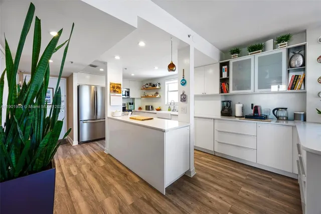 a kitchen view with appliances and wooden floor