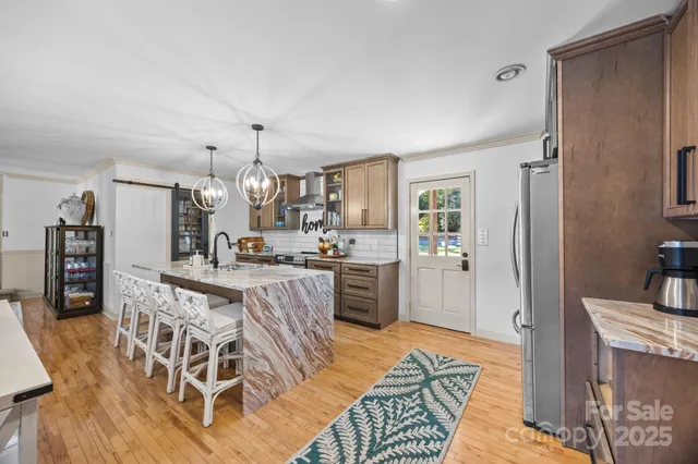 a kitchen with stainless steel appliances kitchen island granite countertop a refrigerator and microwave