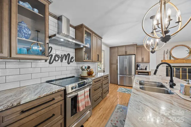a kitchen with stainless steel appliances granite countertop a stove and a sink