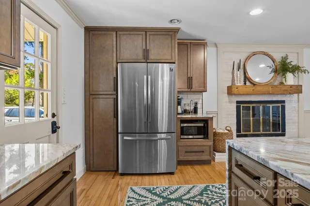 a kitchen with granite countertop stainless steel appliances a counter space and wooden floor