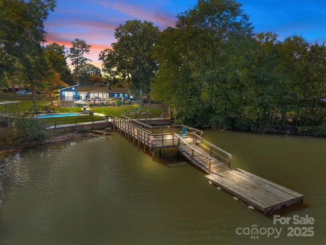 a view of residential houses with outdoor space lake and trees