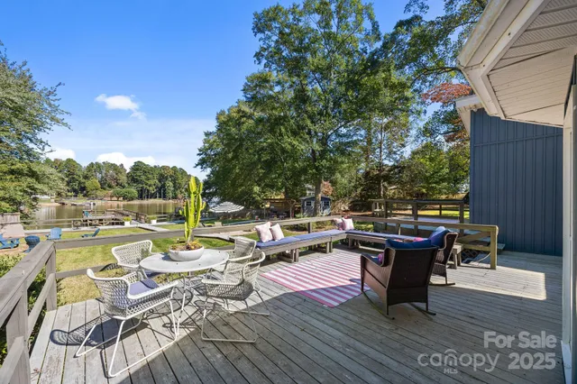 a view of a roof deck with lawn chairs wooden floor and fence