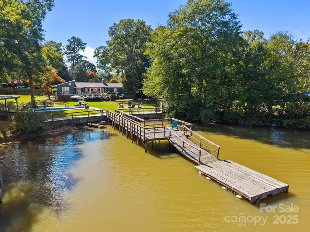 an aerial view of a house with a yard and lake view