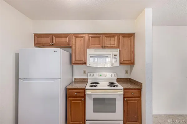 a kitchen with a refrigerator stove and white cabinets
