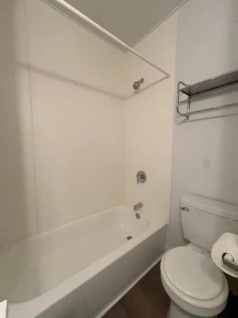 a white toilet and tub sitting next to a bathroom sink