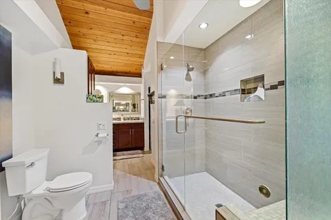 a bathroom with a granite countertop sink a toilet and shower