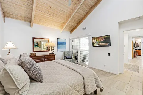 a bedroom with a large bed and a chandelier