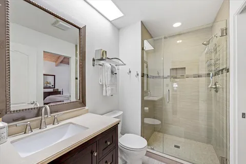 a bathroom with a sink a toilet a mirror and shower