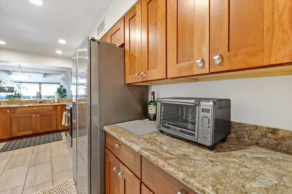 a kitchen with kitchen island granite countertop wooden cabinets and sink