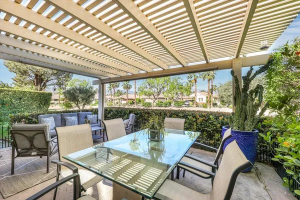 a view of a patio with a dining table and chairs with wooden floor and fence