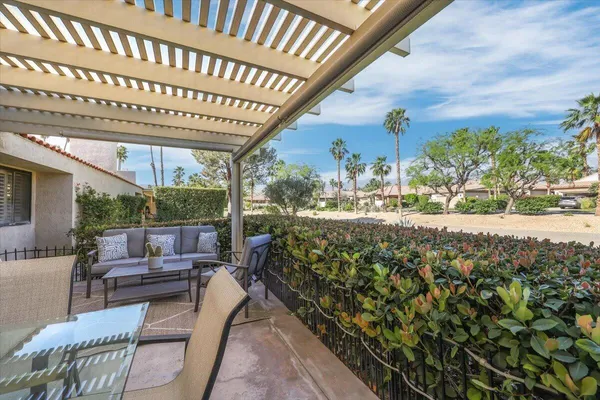 a view of a patio with couches table and chairs and potted plants