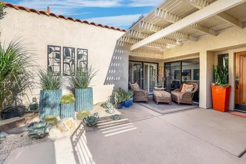 a living room with furniture and potted plants