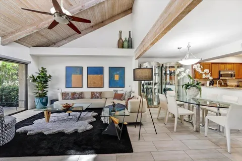 a living room with lots of furniture and a painting on the wall