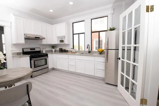 a kitchen with a sink appliances cabinets and a window