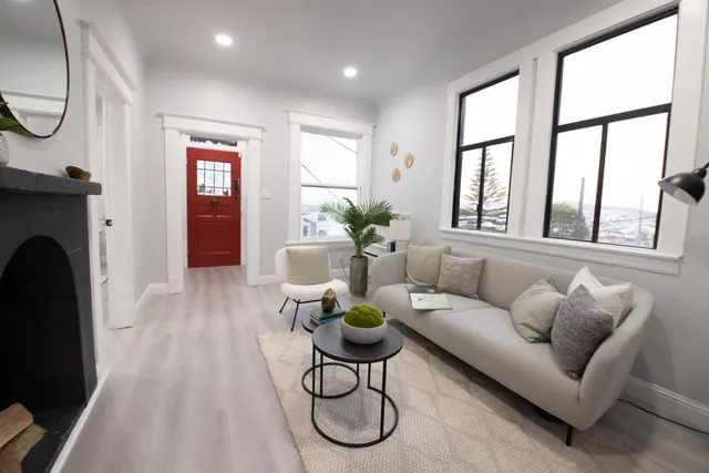 a living room with furniture a fireplace and a floor to ceiling window