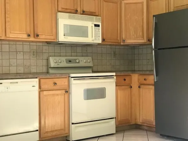 a kitchen with granite countertop white cabinets and white appliances