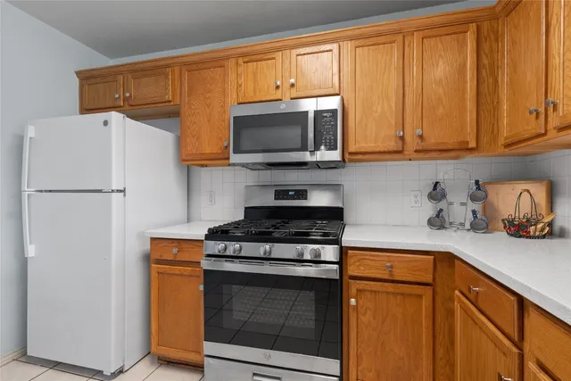 a kitchen with stainless steel appliances granite countertop a refrigerator stove and microwave