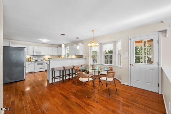 a living room with furniture and kitchen view with wooden floor