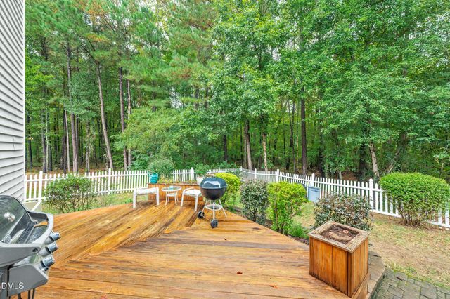 a view of a table and chairs with wooden floor and fence