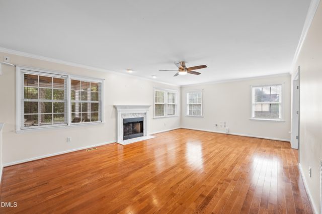 a view of empty room with wooden floor and fireplace