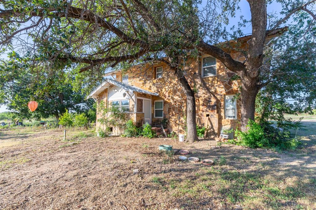 640 Ground Street Moran, TX 76464 - Photo 33 of 35 Stone-clad exterior featuring multiple windows and a prominent front entry with a small porch