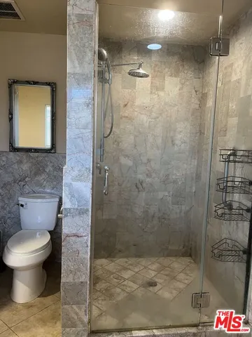 a bathroom with a toilet and a shower