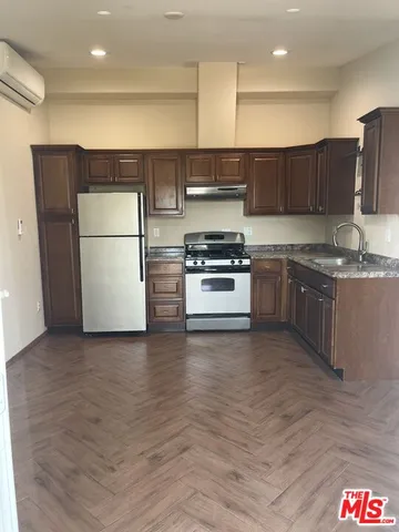a kitchen with stainless steel appliances granite countertop a stove a sink and a refrigerator