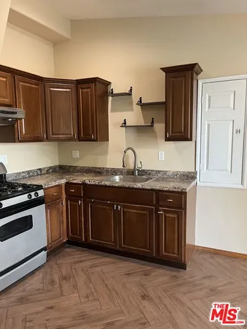 a kitchen with granite countertop wooden cabinets and stainless steel appliances