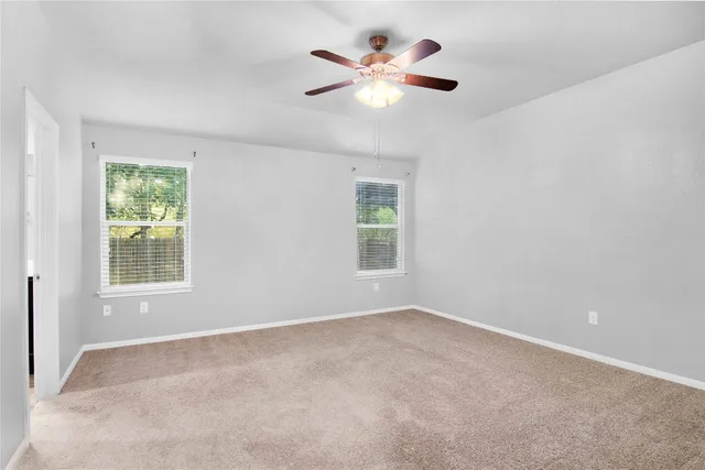 an empty room with a window and a fan