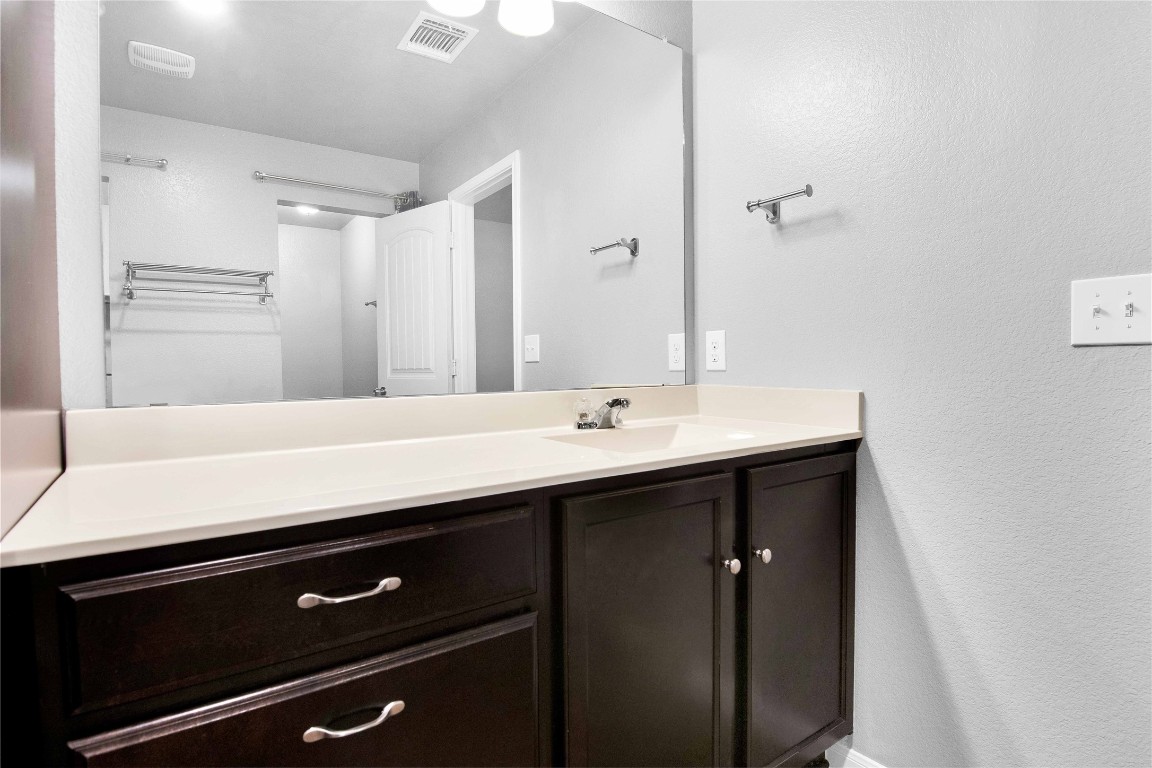 704 Red Tails Drive Austin, TX 78725 - Photo 24 of 37 a bathroom with a sink and a mirror